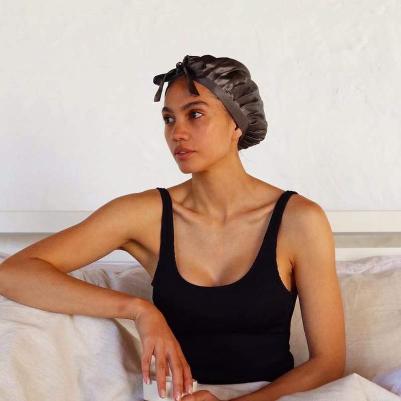 Model wearing grey silk bonnet in bed 